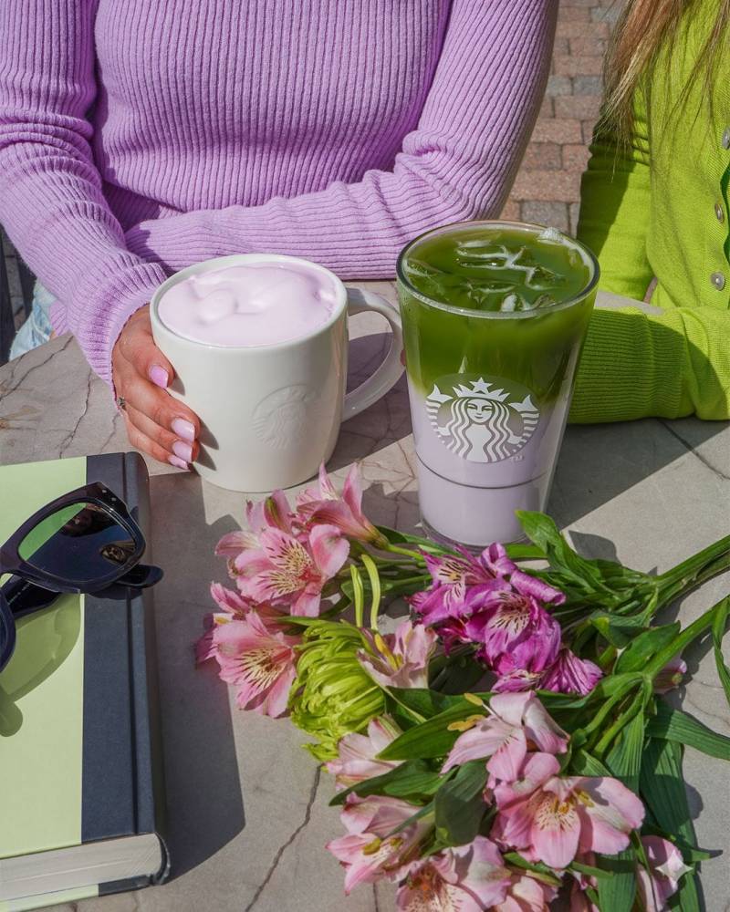A close-up of a creamy, pale green pistachio latte topped with crushed nuts, served in a minimalist glass at a trendy Seoul cafe.