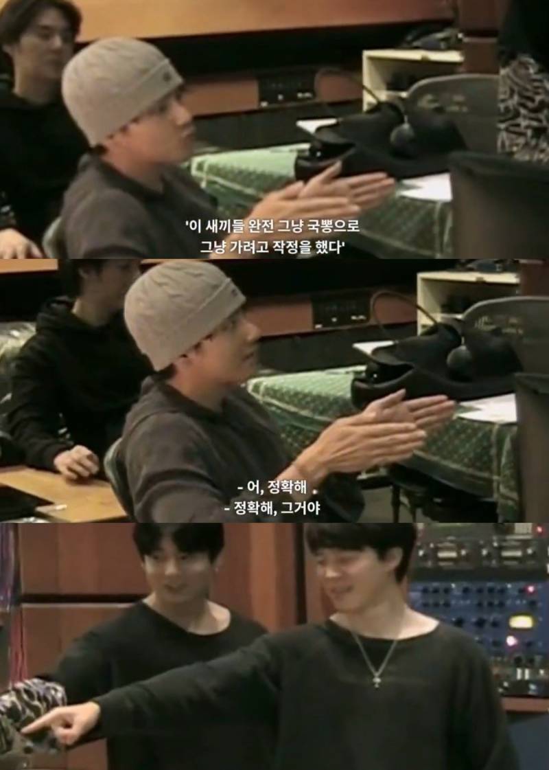 BTS members engaged in a serious discussion during a behind-the-scenes documentary segment, illustrating their collaborative and self-reflective process.