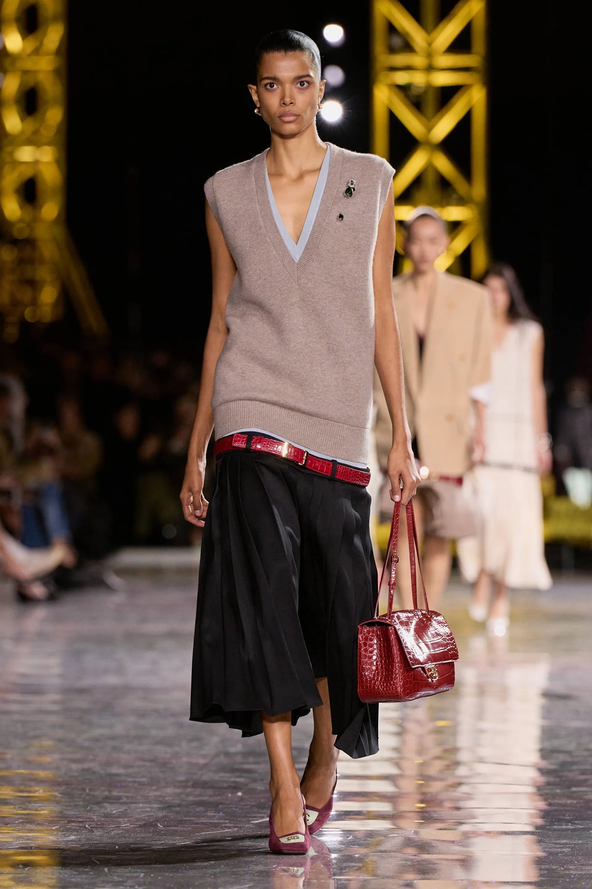 Close up of a Chanel low-waist trouser design featuring intricate tweed patterns and a belt sitting extremely low on the hips.