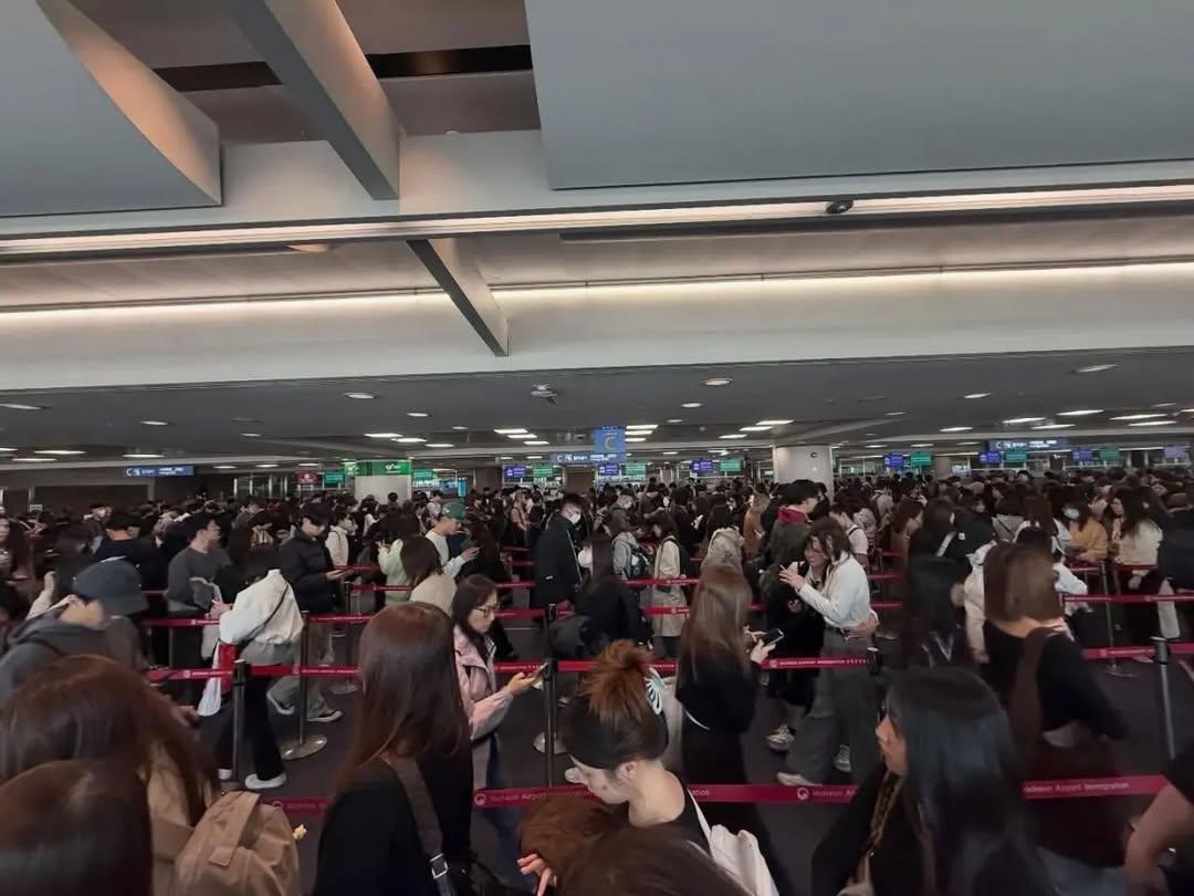 A massive crowd of fans and photographers gathered at Incheon International Airport arrivals gate for BTS