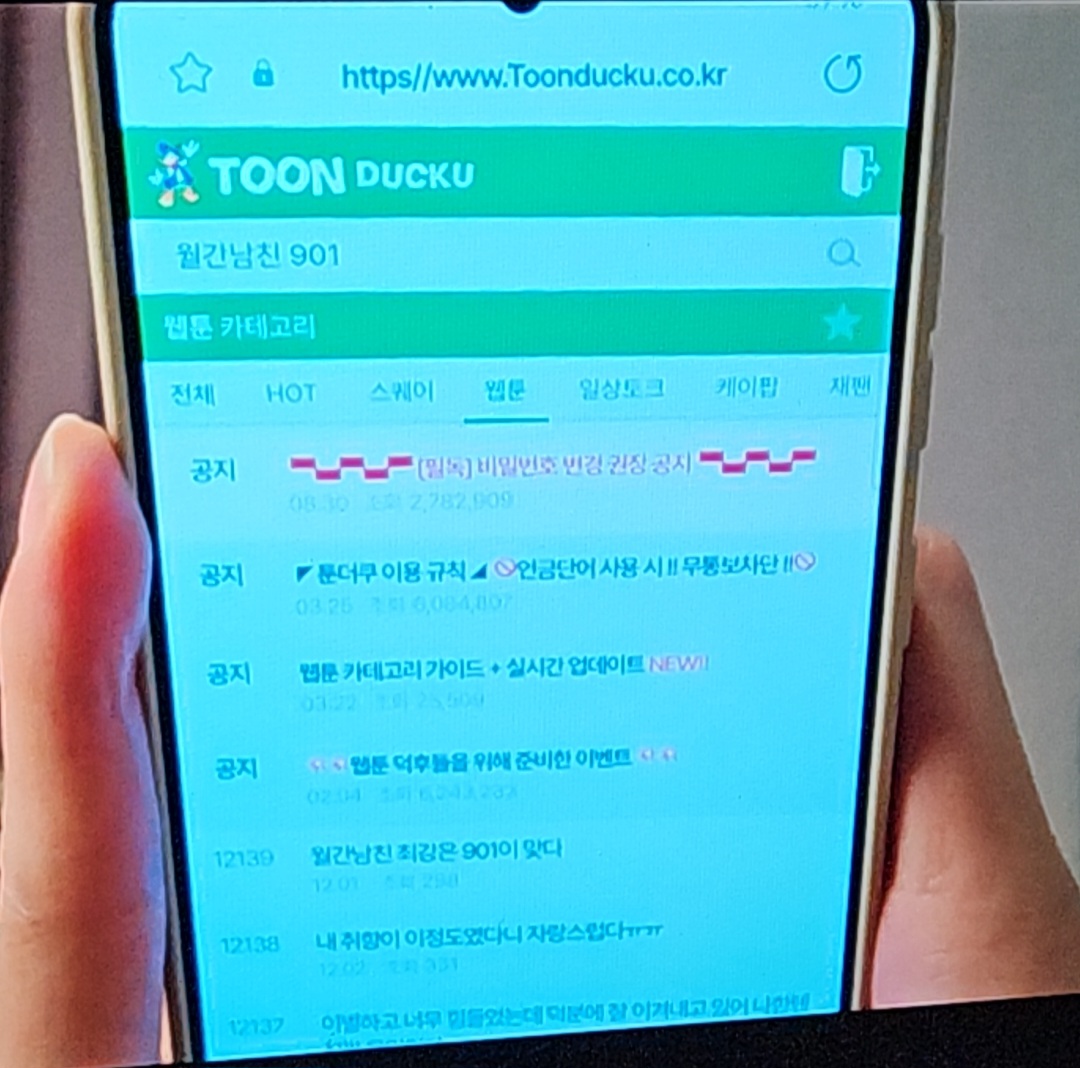 A dynamic screenshot from 'Monthly Boyfriend' showing a male character in a cozy indoor setting, possibly during a video call, highlighting the interactive visual quality.