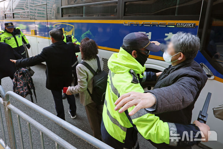 Police officer using a hand scanner on a wedding guest in Seoul