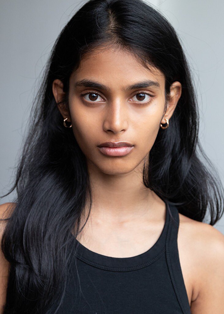 シャネルのランウェイを歩くBhavitha Mandava。黒いドレスを着て堂々とした表情。