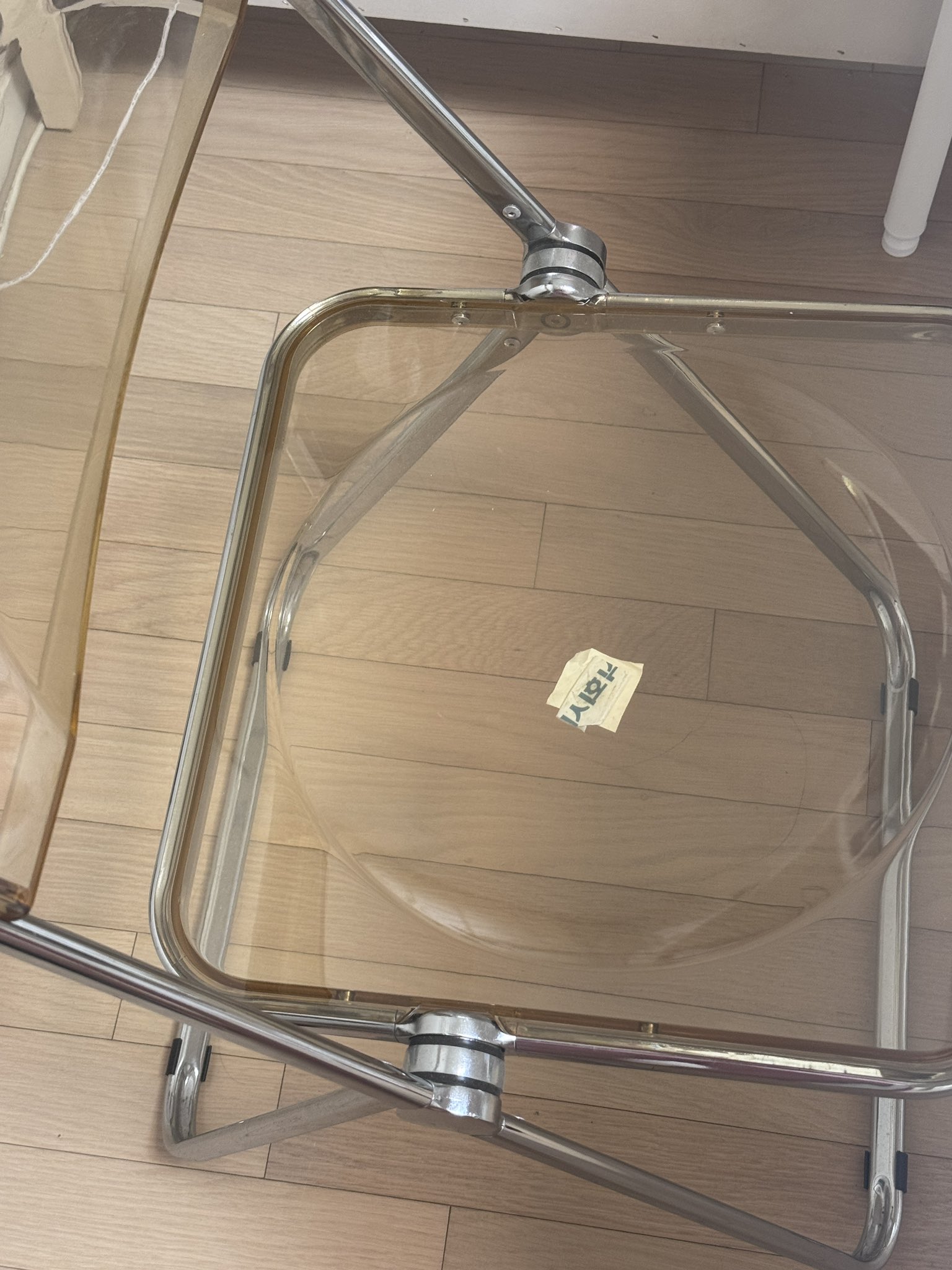 A mysterious 'King' symbol written in red on a piece of paper taped to the bottom of a chair.