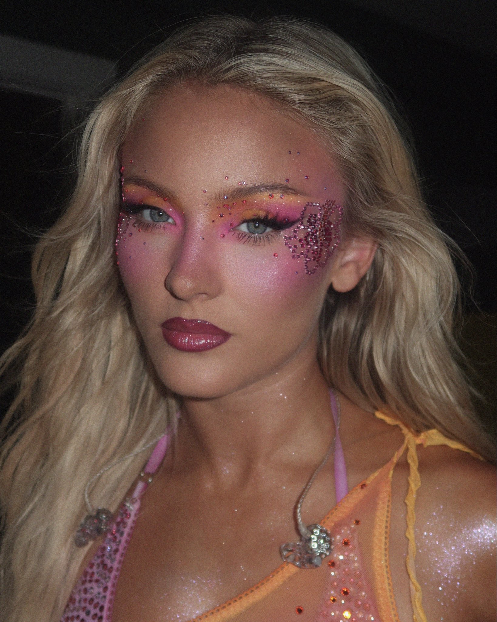 Zara Larsson smiling, showcasing a full face of natural-looking makeup with a focus on glowing skin and soft lips.