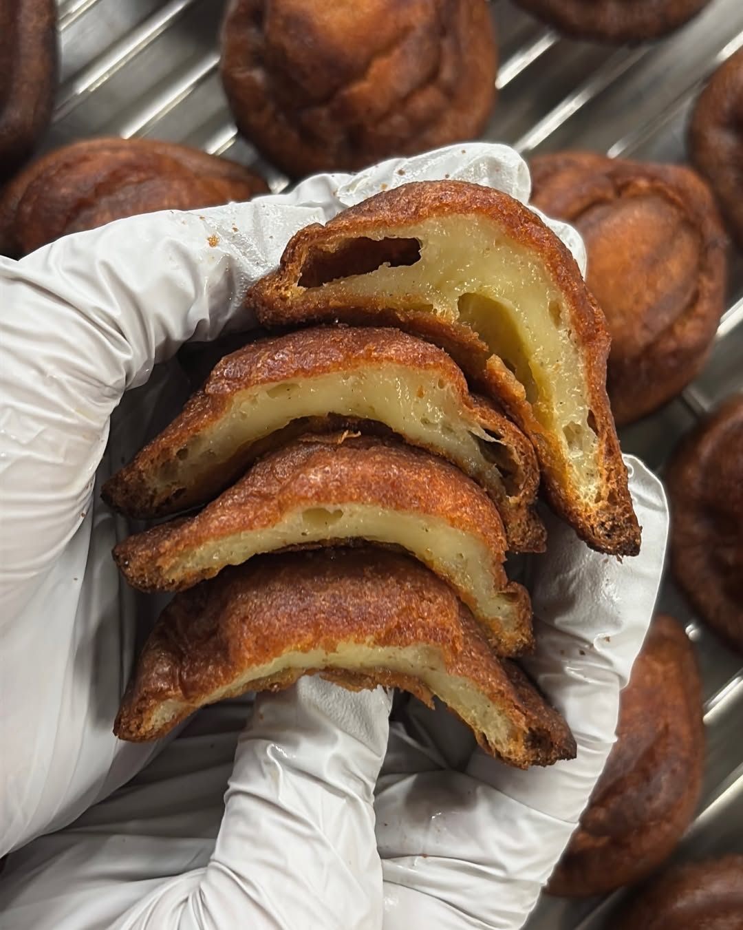 Butter Tteok recién cortado en rebanadas, revelando su interior blanco y masticable y su exterior dorado.
