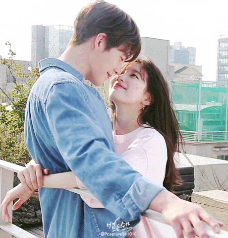 A romantic K-drama couple exchanges glances while walking, highlighting their visual appeal and connection.