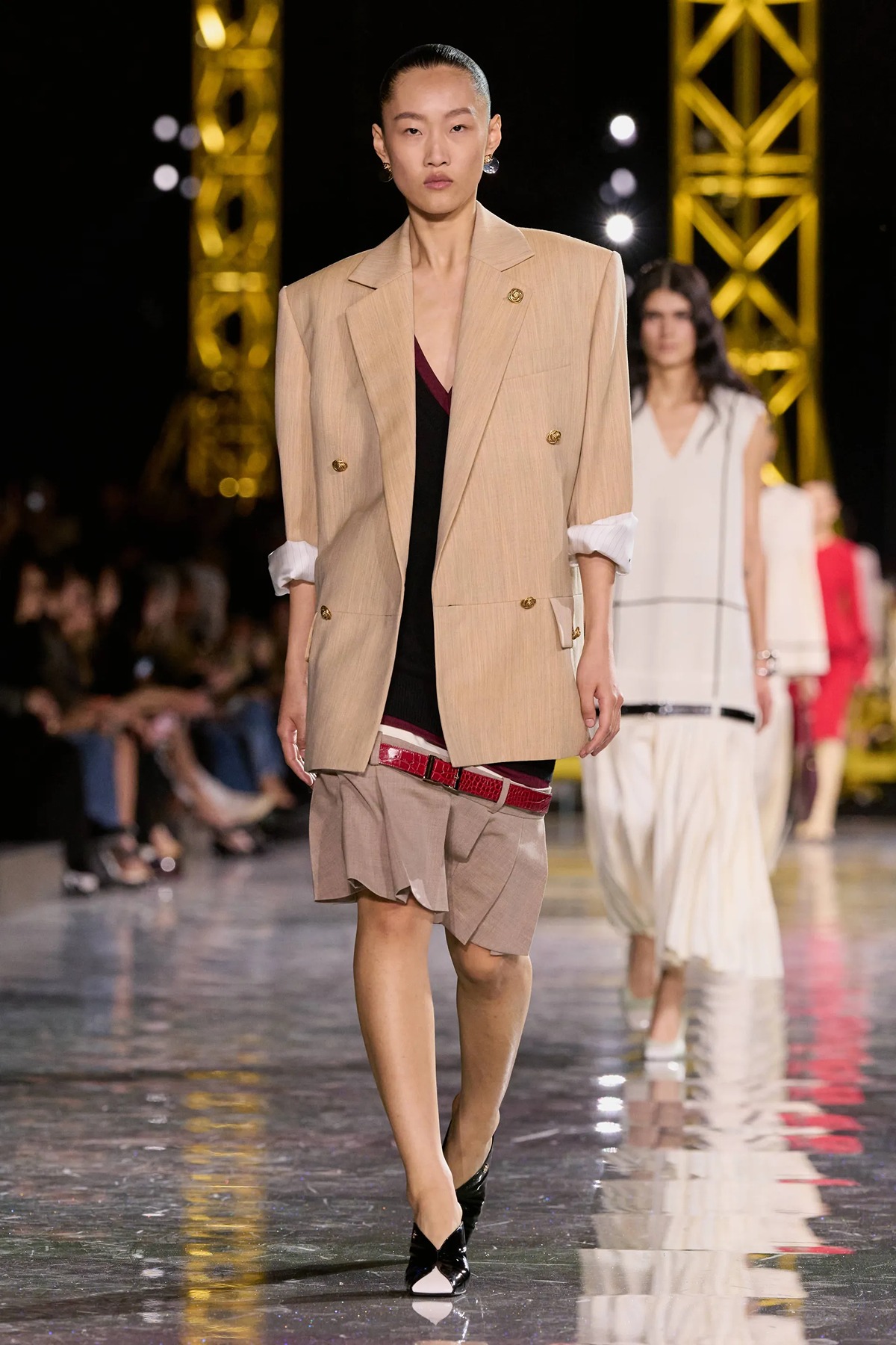 A full-length shot of a model in a Chanel low-waist dress that creates a long, lean silhouette, emphasizing the lowered waistline trend.