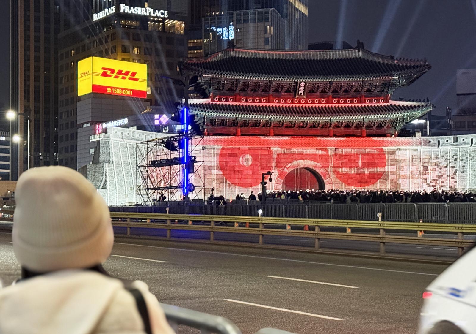 A secondary view of the BTS Gwanghwamun branding materials showing the logo in context.