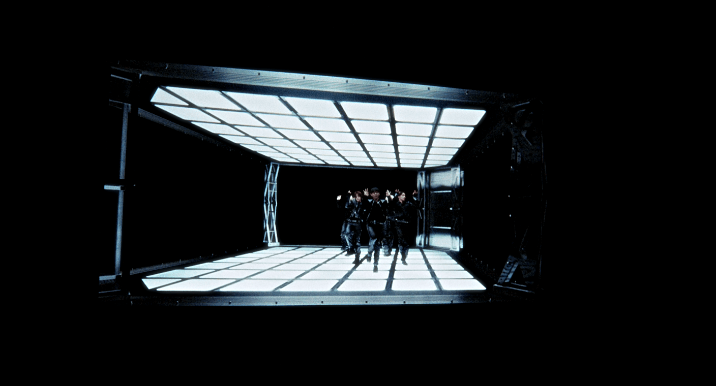 The five members of KIBITUP posing together in a stylized studio shot with warm lighting