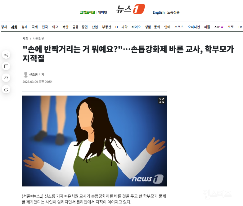 Close-up of a hand with short, neat nails, possibly wearing a clear nail strengthener, against a blurred background.