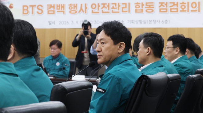 Attendees at the Seoul City Hall meeting reviewing documents and projections for the event, highlighting the detailed planning.