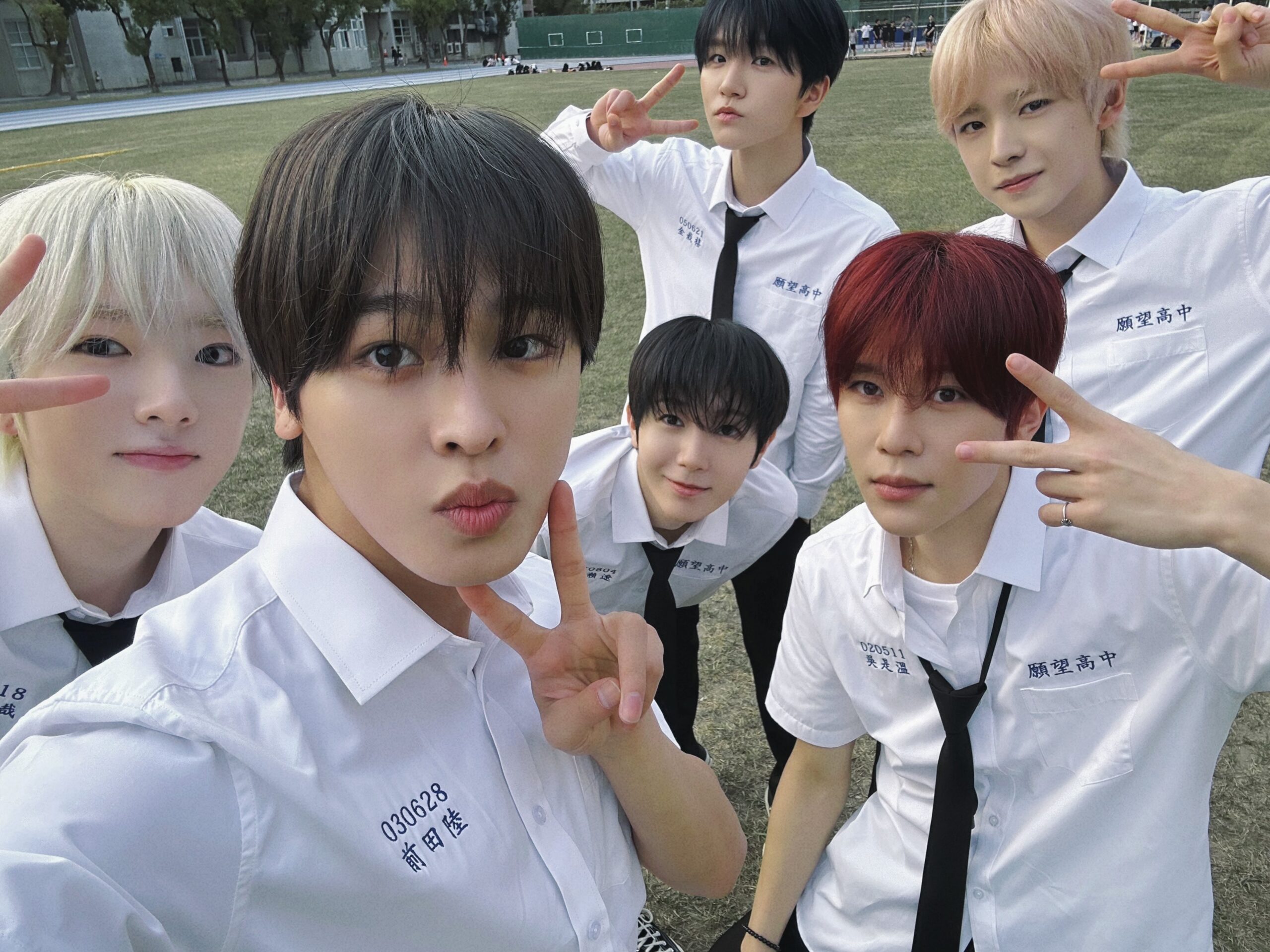 NCT WISH members smiling and interacting in their school uniforms