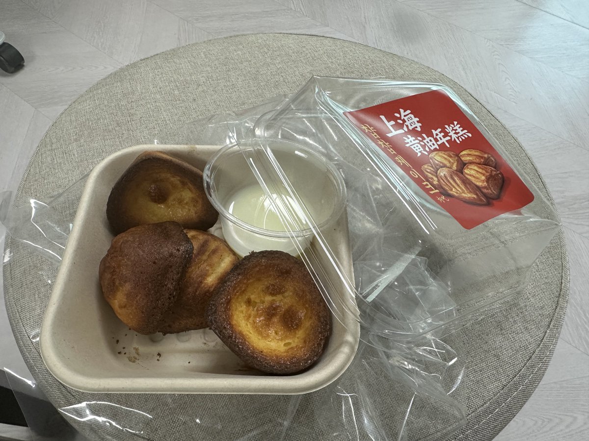 A close-up shot of golden-brown butter tteok squares stacked neatly, showing a crispy exterior and chewy interior.