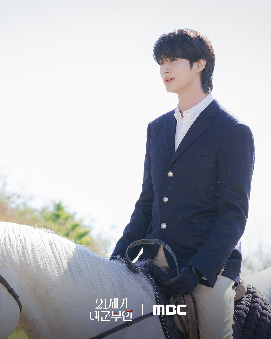 Byeon Woo-seok as Grand Prince Ian looking sharp in a navy royal suit, showcasing the 21st-century royal aesthetic.
