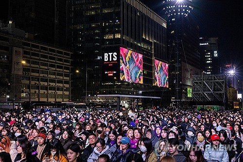 A massive crowd gathers at Gwanghwamun Square for the BTS comeback performance in 2026, showing the scale of the event.