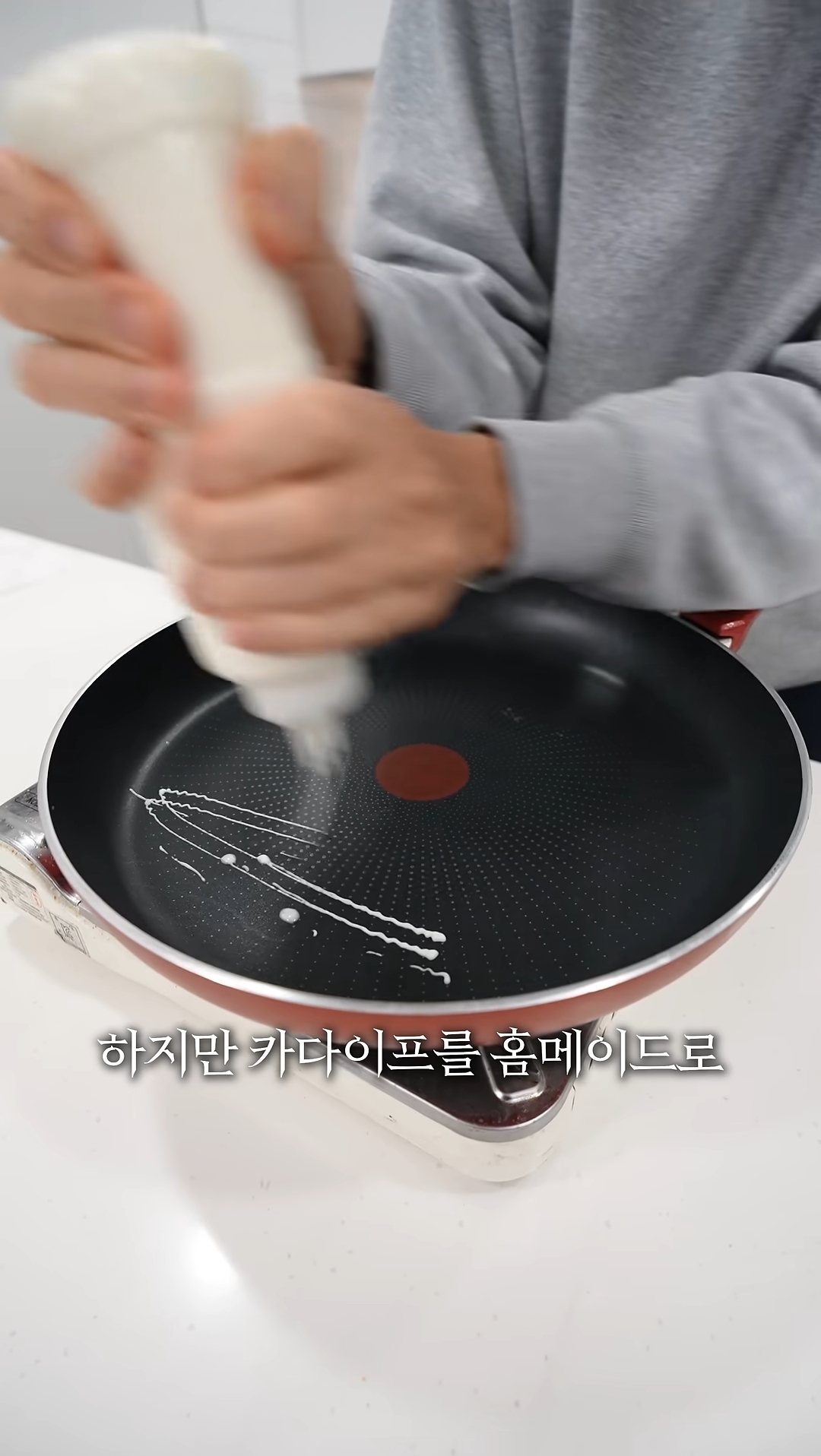 Golden brown Kadaif strands being scraped off the machine, looking perfectly thin and crispy.