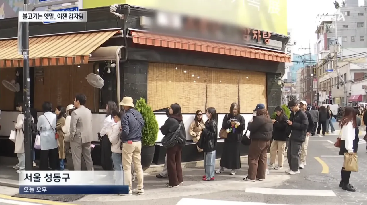 A steaming pot of Gamjatang with rich red broth and large pork bones
