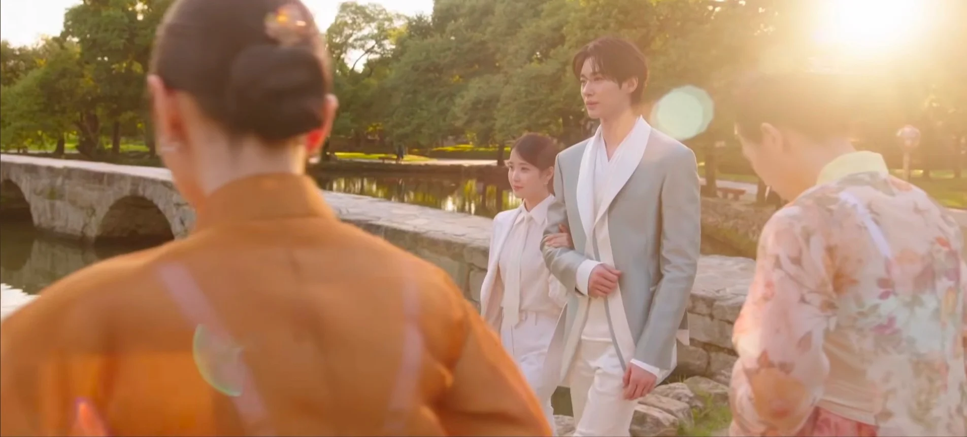 A medium shot of IU looking up at Byeon Woo-seok, highlighting the steep angle required for eye contact