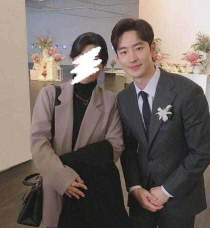 Lee Je-hoon standing among a crowd, his visuals standing out even in a blurry shot